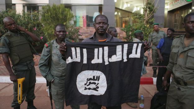 Maliani mostrano la bandiera portata dai terroristi durante il massacro in Mali