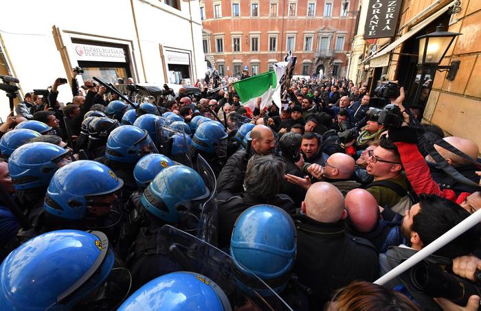 Un gruppo di tassisti e di ambulanti protestano davanti alla sede del Pd a Roma. 