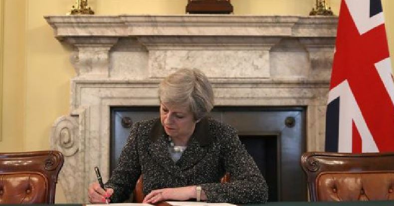 Theresa May mentre firma la notifica su Brexit