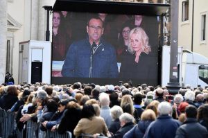 Carlo Conti e Antonella Clerici sul maxischermo all'esterno della chiesa degli Artisti durante i funerali di Fabrizio Frizzi, Roma, 28 marzo 2018. ANSA/ ETTORE FERRARI